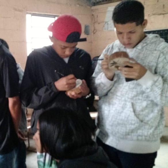 Grupo de adolescentes trabalhando madeira com pirógrafo